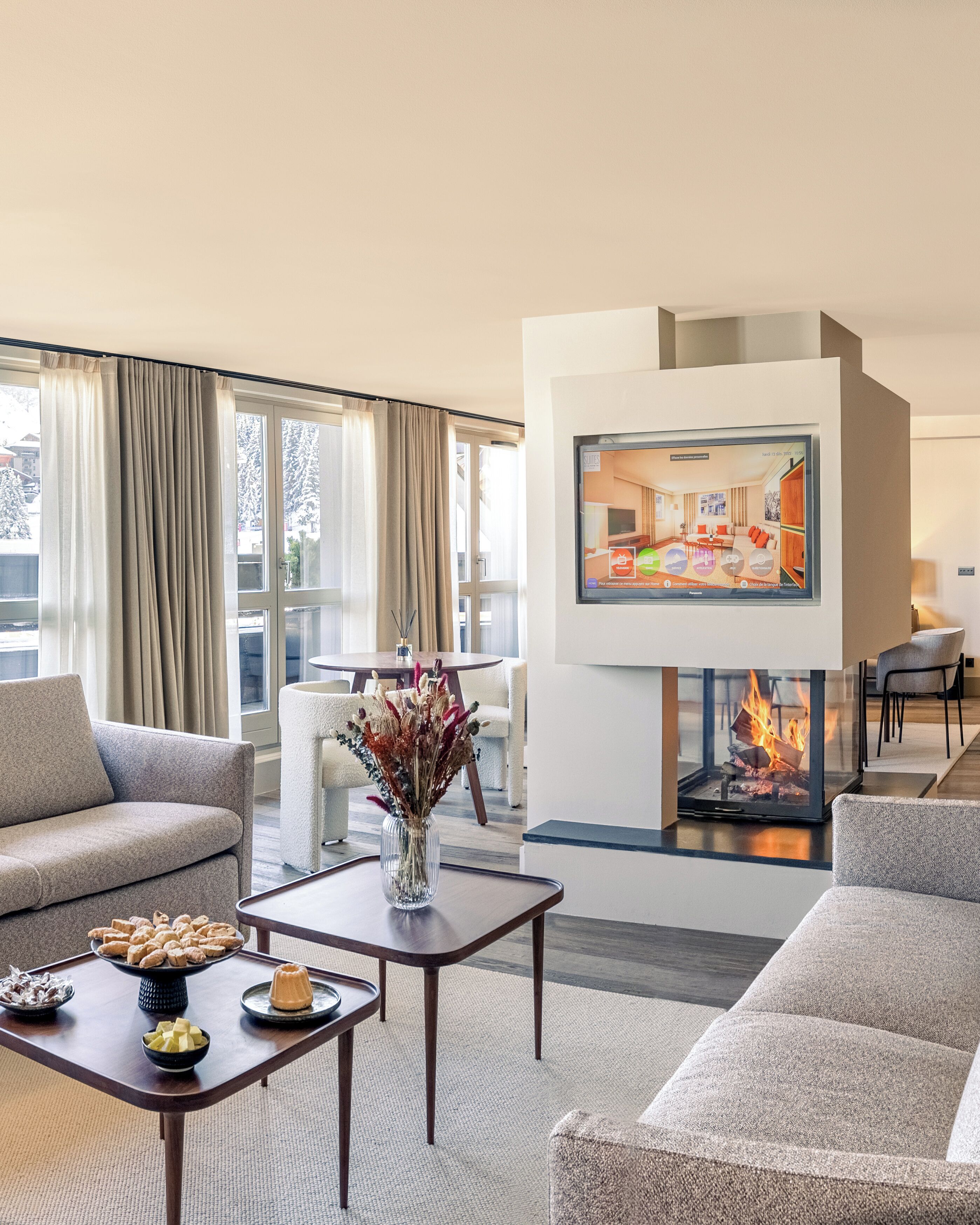 A modern living room with a fireplace, a dining area, and a sofa.