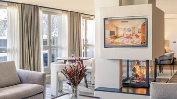 A modern living room with a fireplace, a dining area, and a sofa.