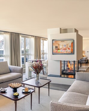 Una sala de estar moderna con chimenea, comedor y sofá.