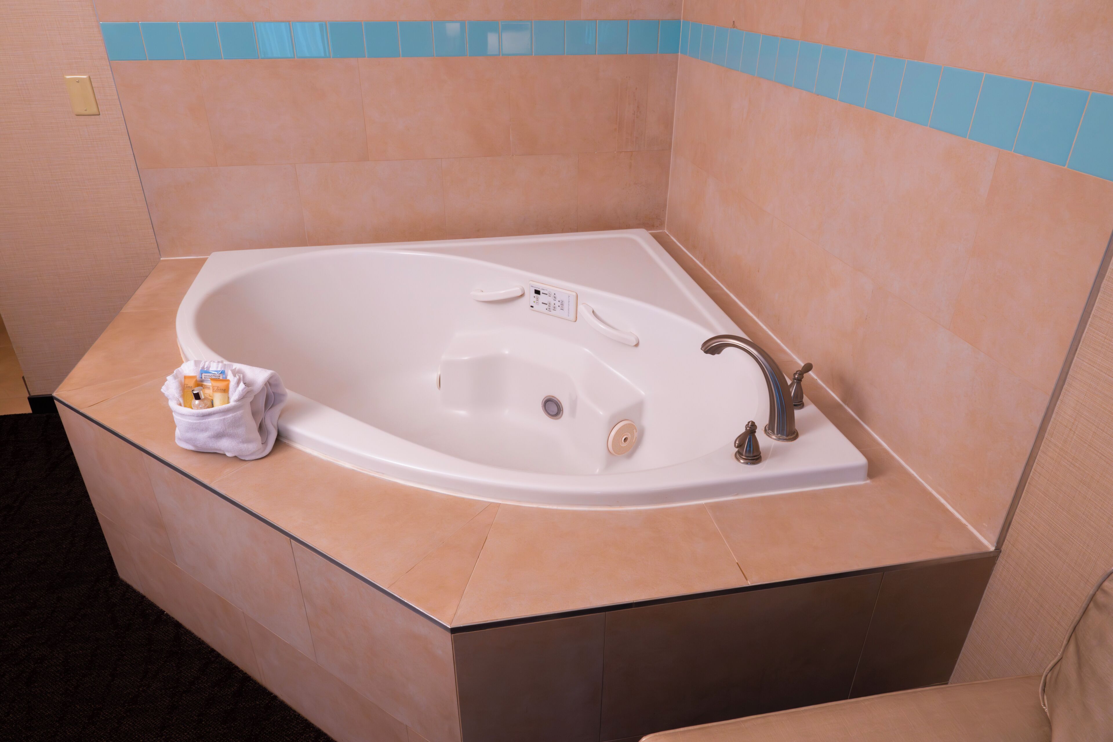 A modern bathroom with a freestanding bathtub, a towel rack, and a small trash bin.