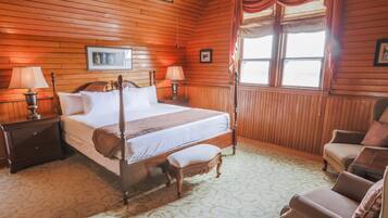 A wooden-paneled bedroom with a four-poster bed, two bedside lamps, a wooden bench, and a chair.