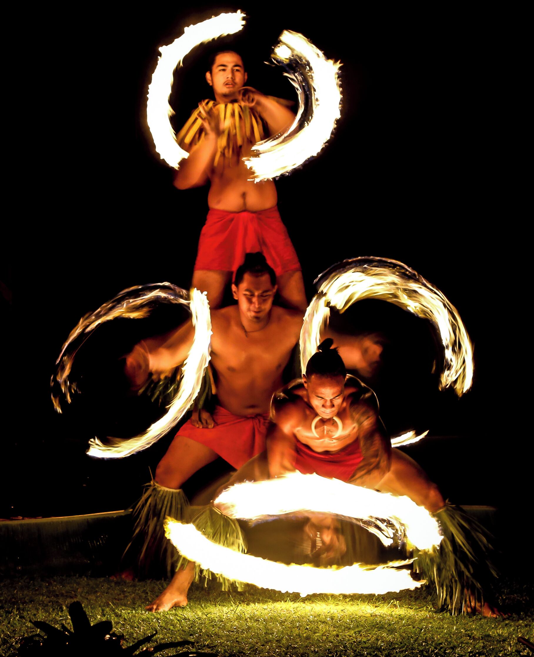 Un grupo de artistas con aros de fuego, sugiriendo un evento o espectáculo al aire libre.