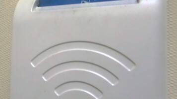Un dispositivo blanco con una tarjeta azul insertada, que muestra un logotipo y texto.