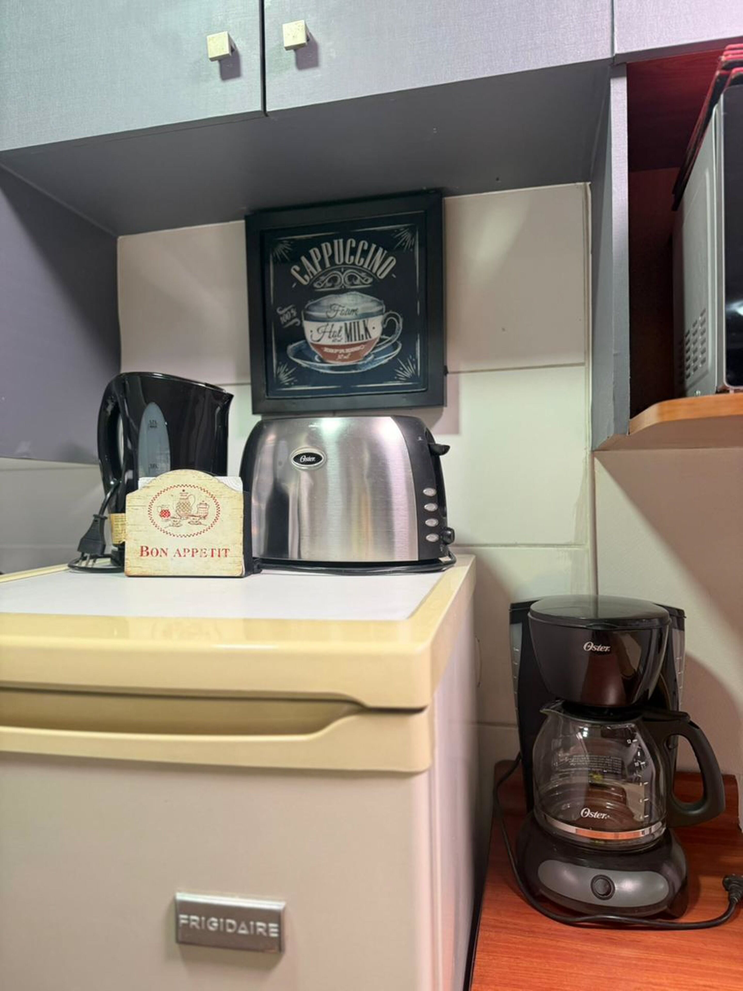 Une cuisine équipée d’une machine à café, d’un grille-pain et d’un réfrigérateur.