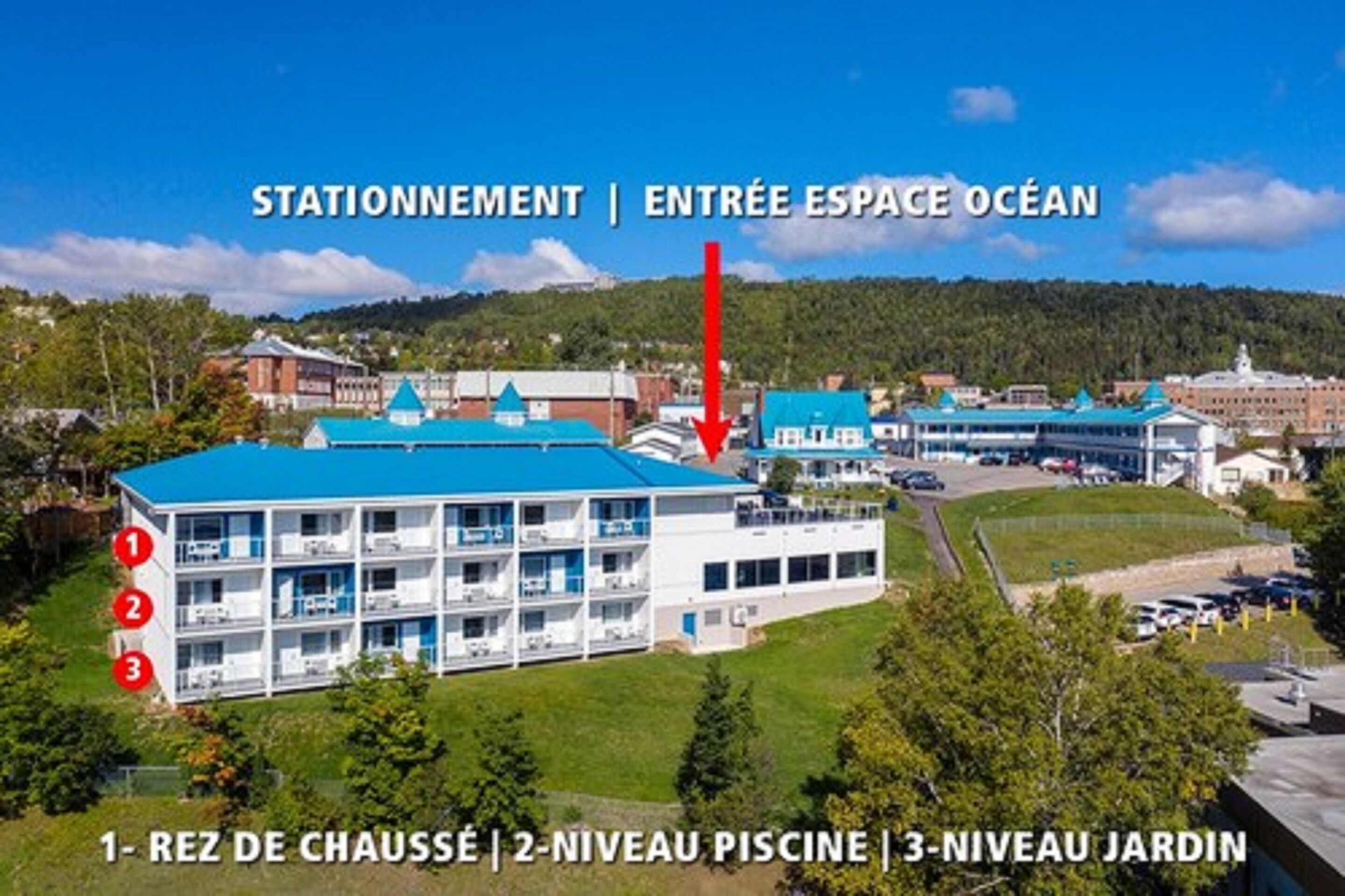 A hotel with a blue roof, a swimming pool, and a garden level.