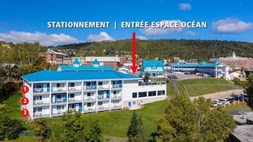 A hotel with a blue roof, a swimming pool, and a garden level.