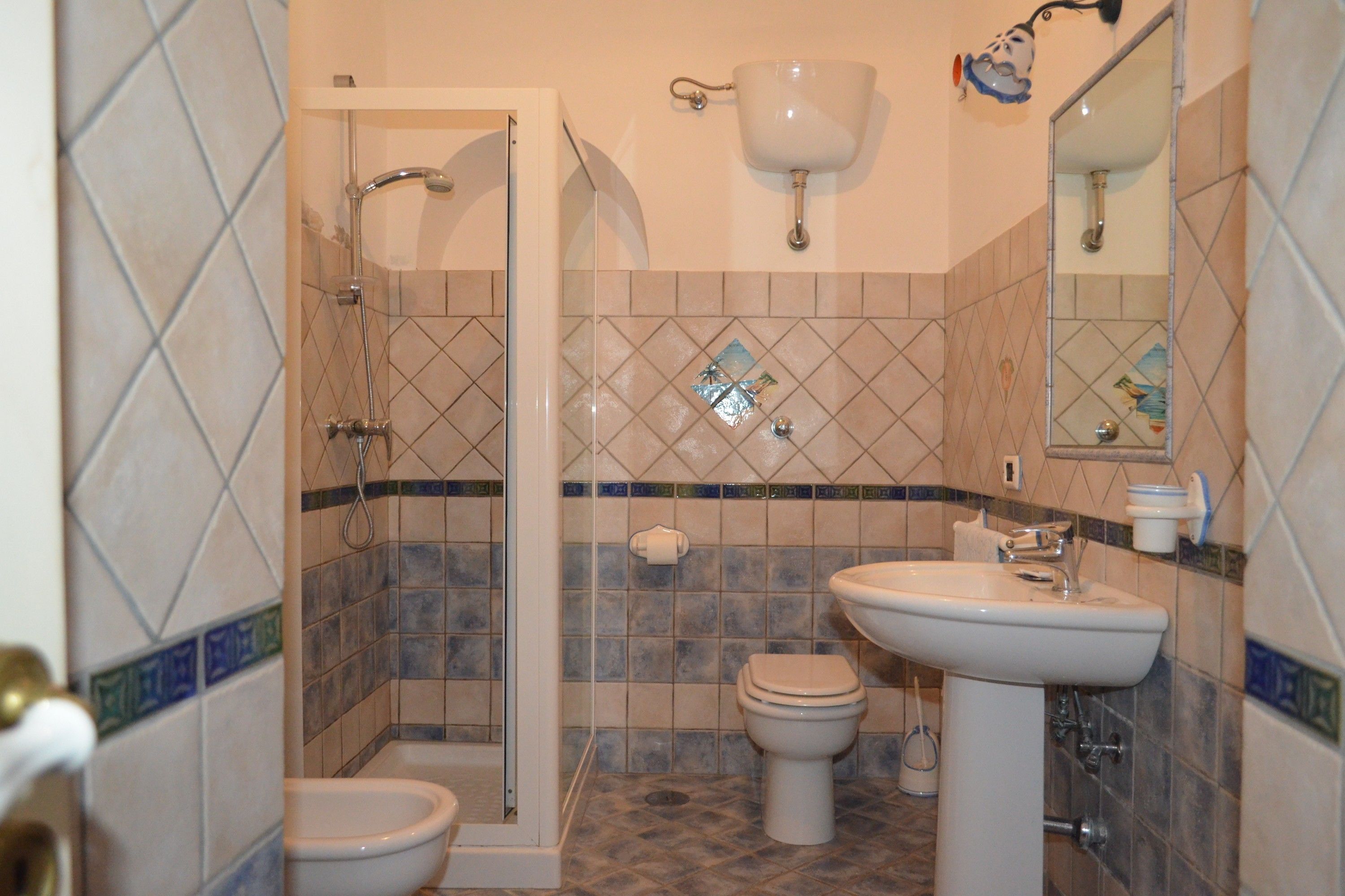 Een badkamer met een douche, toilet en wastafel.
