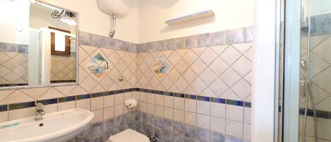 A bathroom with a sink, toilet, and shower.