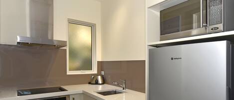 Una cocina moderna con electrodomésticos de acero inoxidable, un ventanal y un horno empotrado.