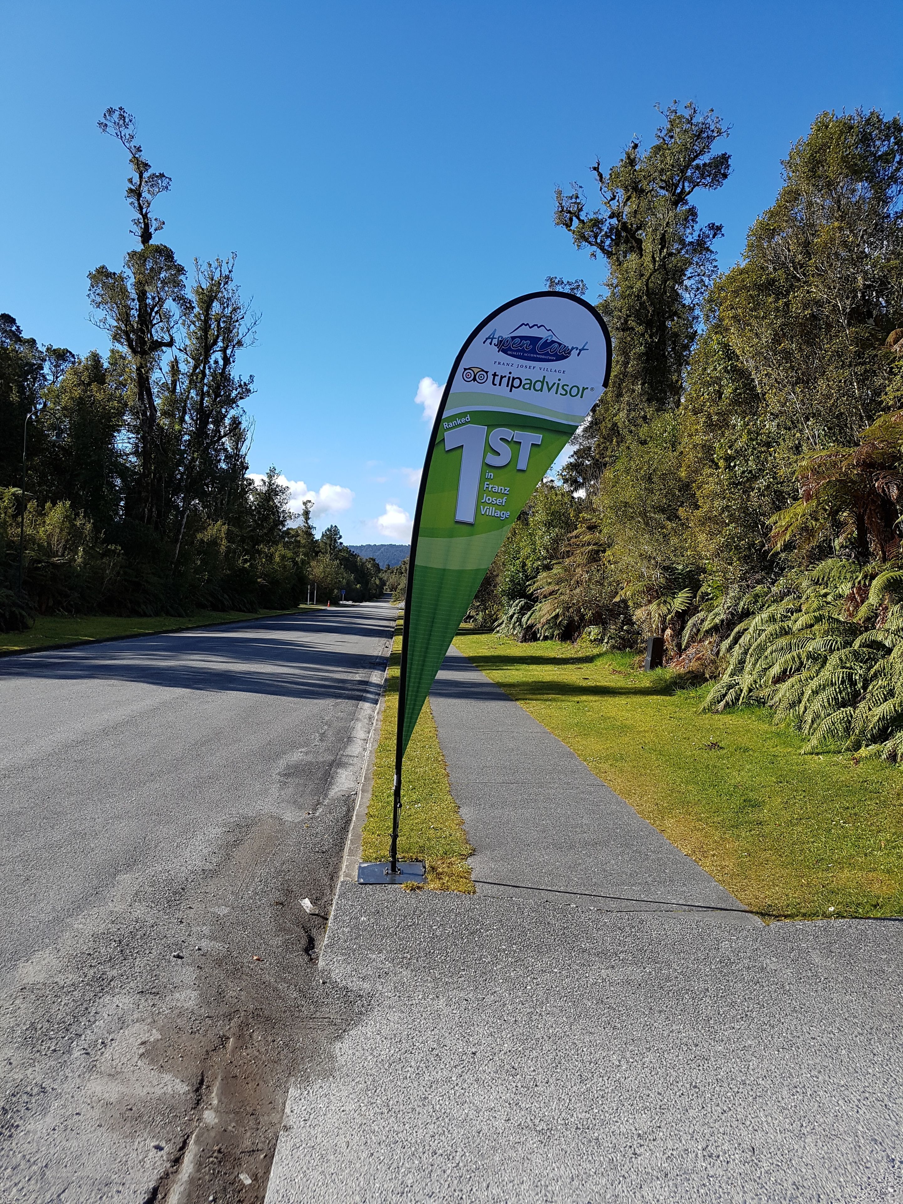 A road sign indicating Franz Josef Village is ranked 1st in tripadvisor.