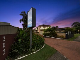 Um motel com uma placa indicando que é o número 203 na Kennedy Drive.