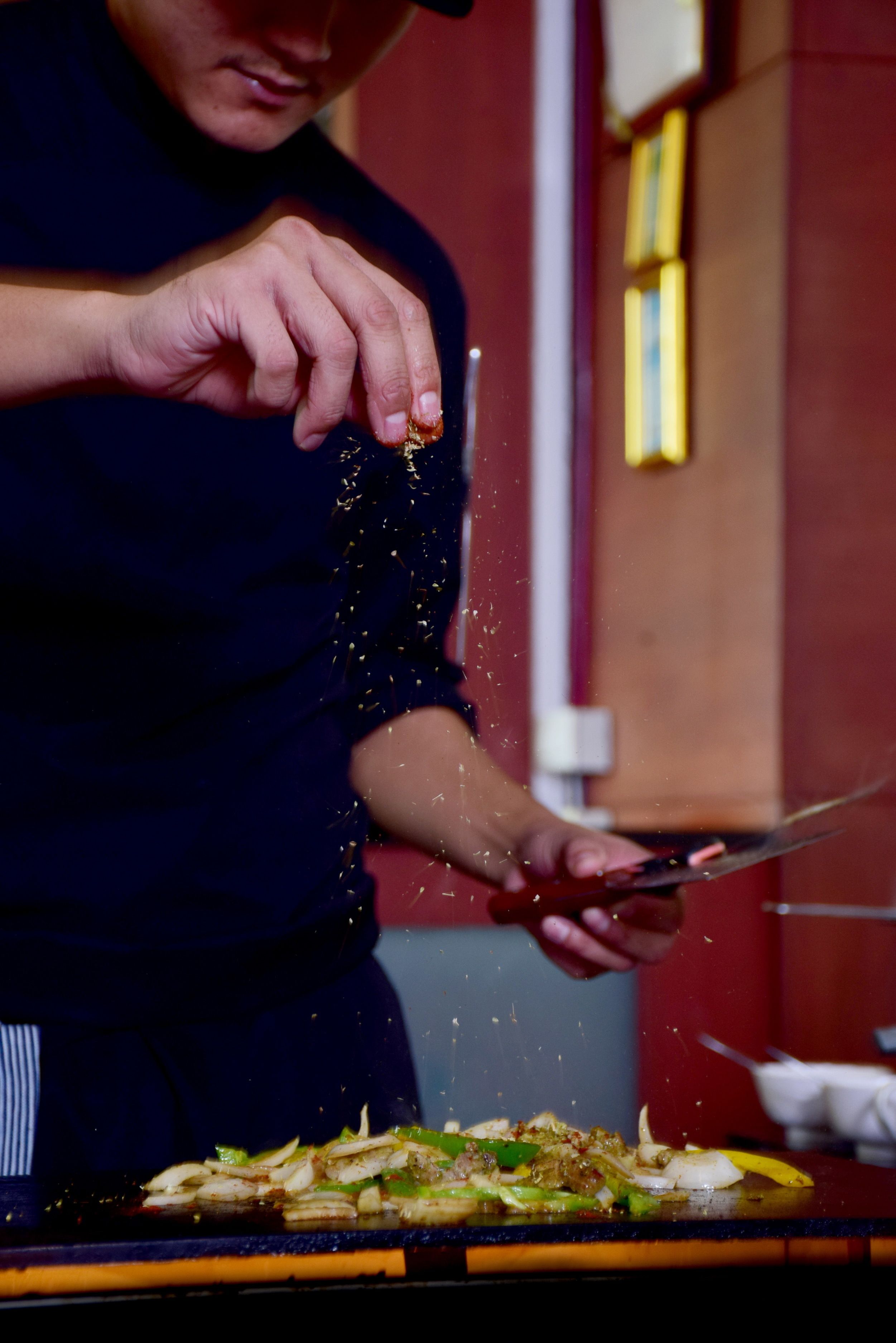 A person seasoning food on a cutting board.