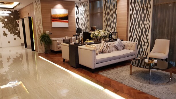 Een moderne woonkamer met een beige bank, een bijzettafeltje en decoratieve accessoires.