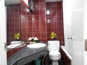 Uma casa de banho com duas pias, uma sanita e um espelho.
