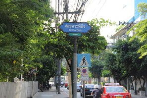 Uma rua com placa de faixa de pedestres, placa de proibido estacionar e visor de taxímetro.