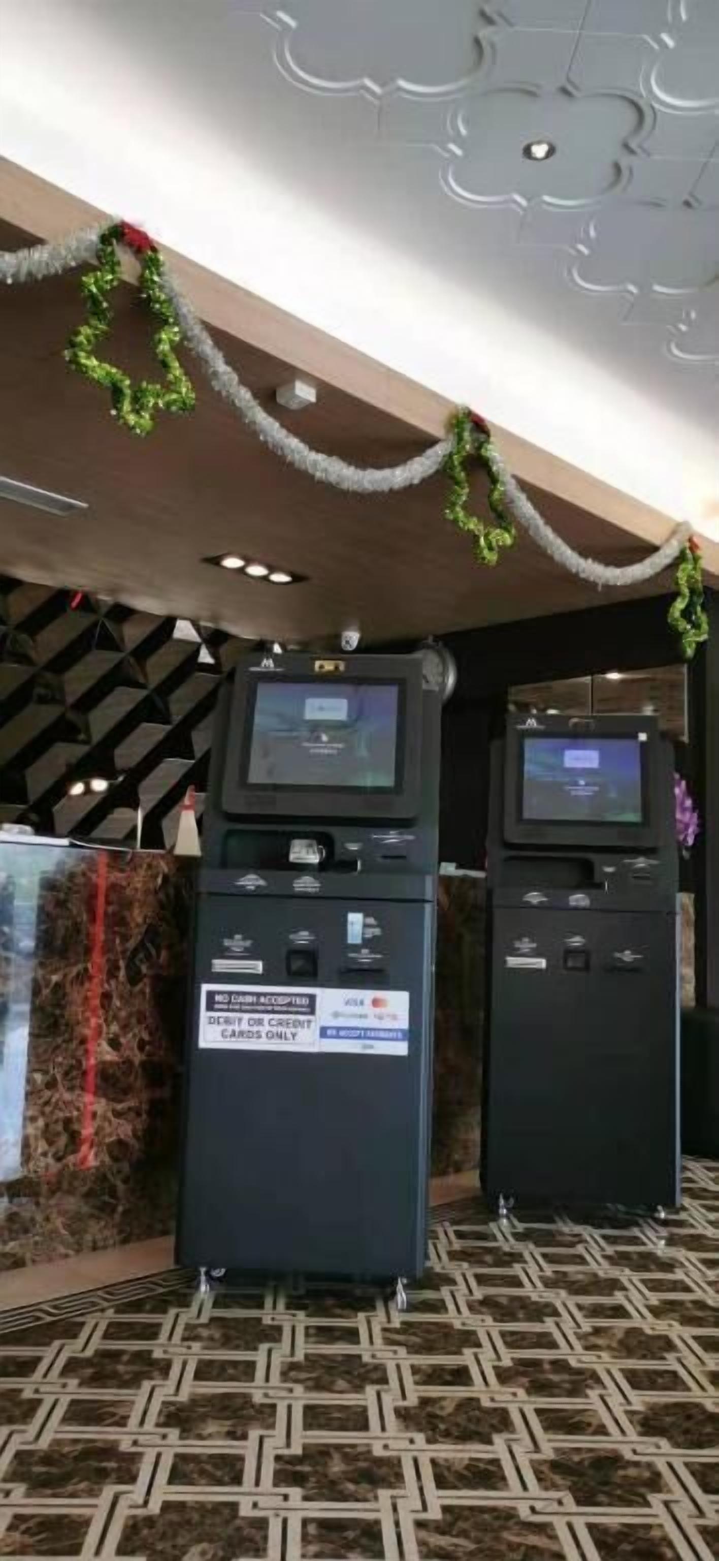Two ATMs with a sign indicating they accept debit or credit cards only.