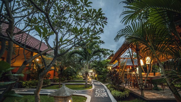 A pathway leading to a building with a tiled roof, surrounded by lush greenery and a well-maintained garden. - Man's Cottages and Spa (Pemuteran)