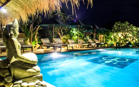 Una piscina al aire libre, sillones reclinables de piscina