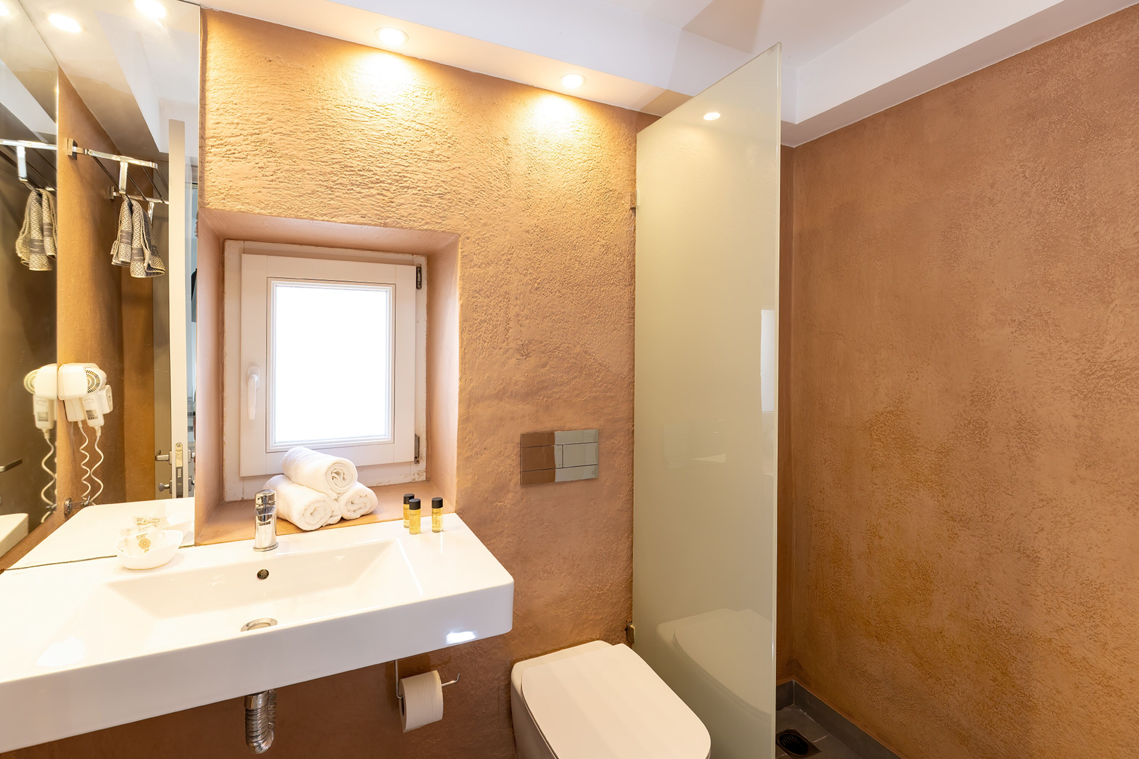 A bathroom with a white sink, a mirror, a towel rack, and a shower area.