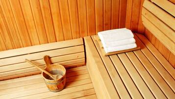 A wooden sauna with benches and a wooden bucket.