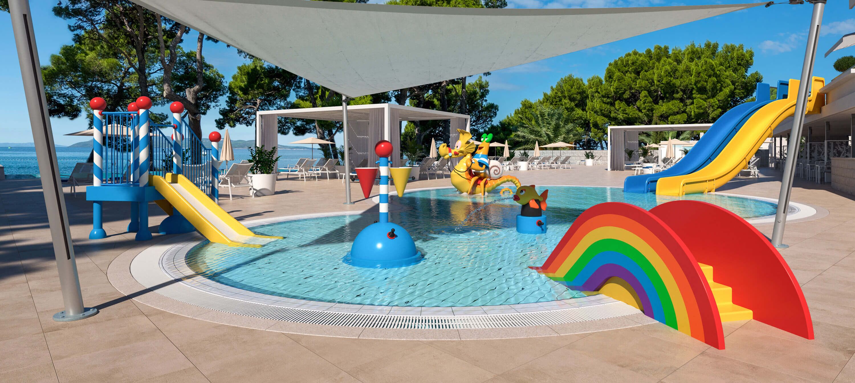 Ein Kinderspielbereich mit Rutschen, einem Pool und Blick auf den Strand.