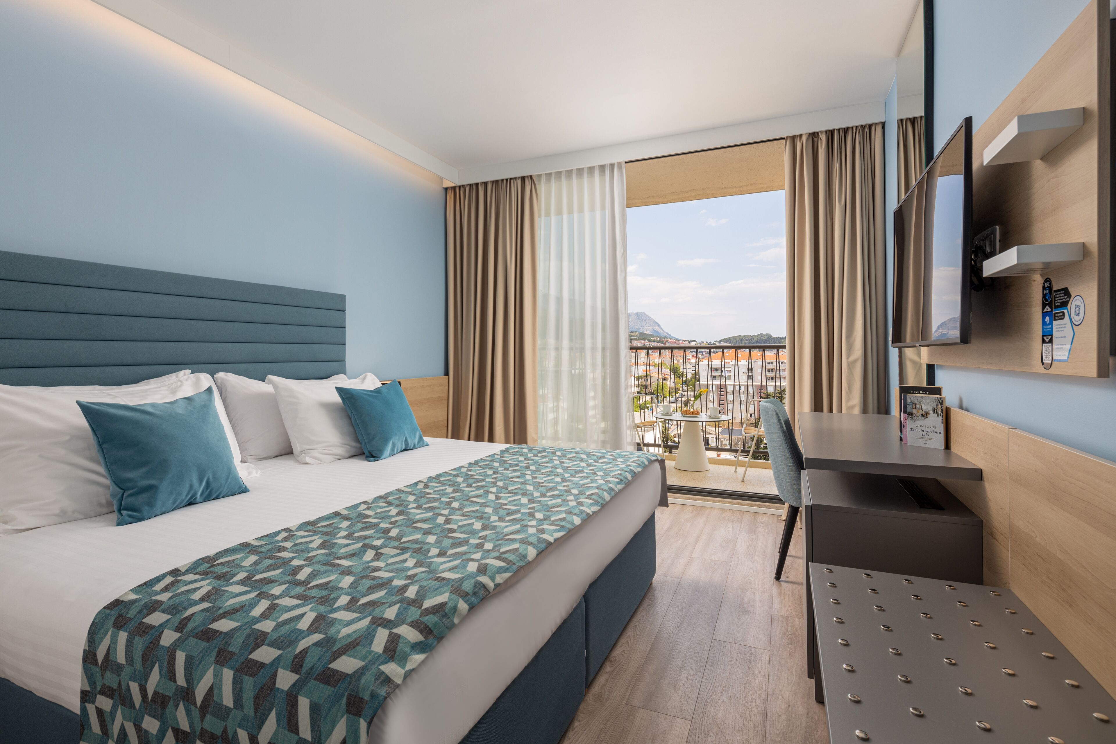 Ein Hotelzimmer mit einem Bett, einem Schreibtisch und einem Fernseher.