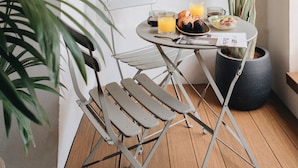 Un petit coin repas avec une table, des chaises et une plante en pot.