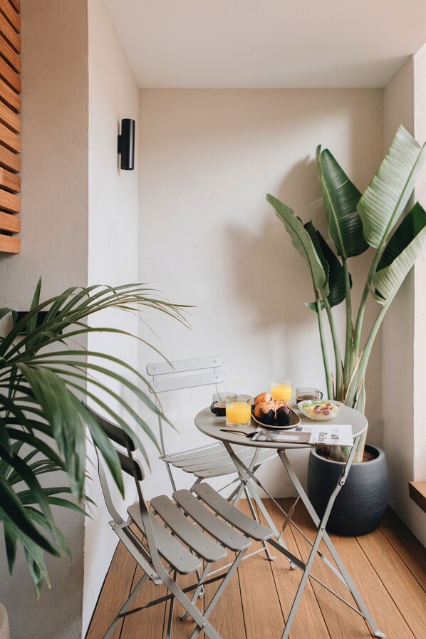A small dining area with a table, chairs, and a potted plant. - Room Mate Oliveira – City Centre, Valencia (Valencia)