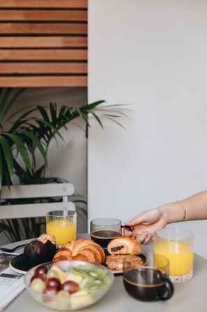 A breakfast table with croissants, fruit, and beverages. - Room Mate Oliveira – City Centre, Valencia (Valencia)
