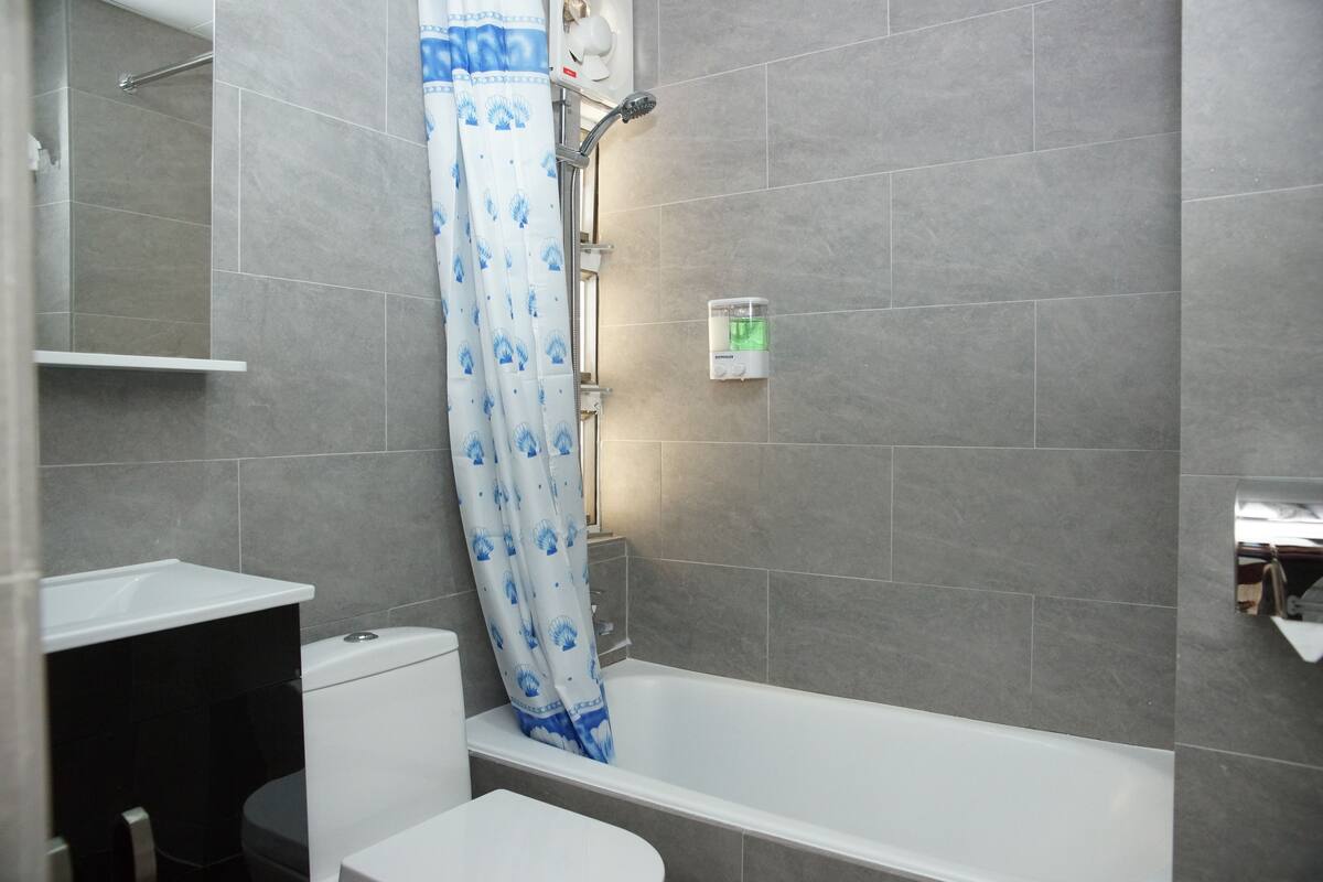 A bathroom with a bathtub, toilet, and shower.
