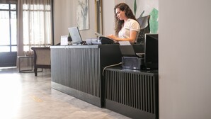 A reception desk with a laptop and a tablet, a chair, and a plant. - Club Zante Plaza (Zakynthos)