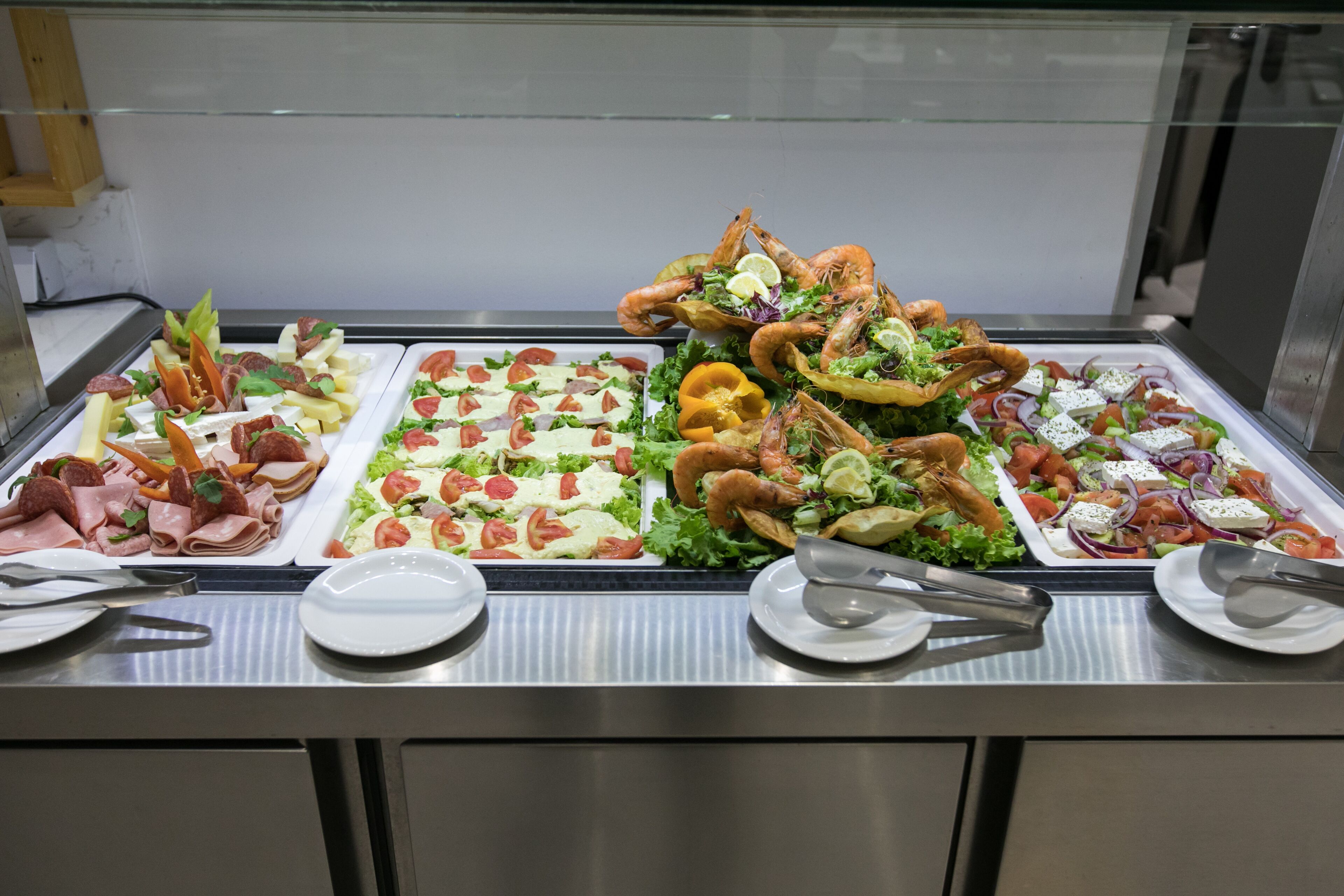 A buffet with various food options including salads, meats, and seafood.