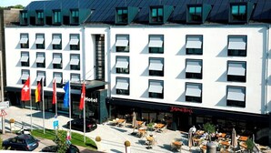 Un hôtel à étages, doté d’une installation de panneaux solaires sur le toit et d’espaces de détente en plein air.