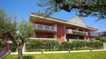 A modern building with a flat roof, large windows, and a red facade.