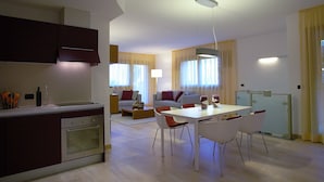 Une cuisine moderne avec un coin repas, un canapé et une table avec des chaises.