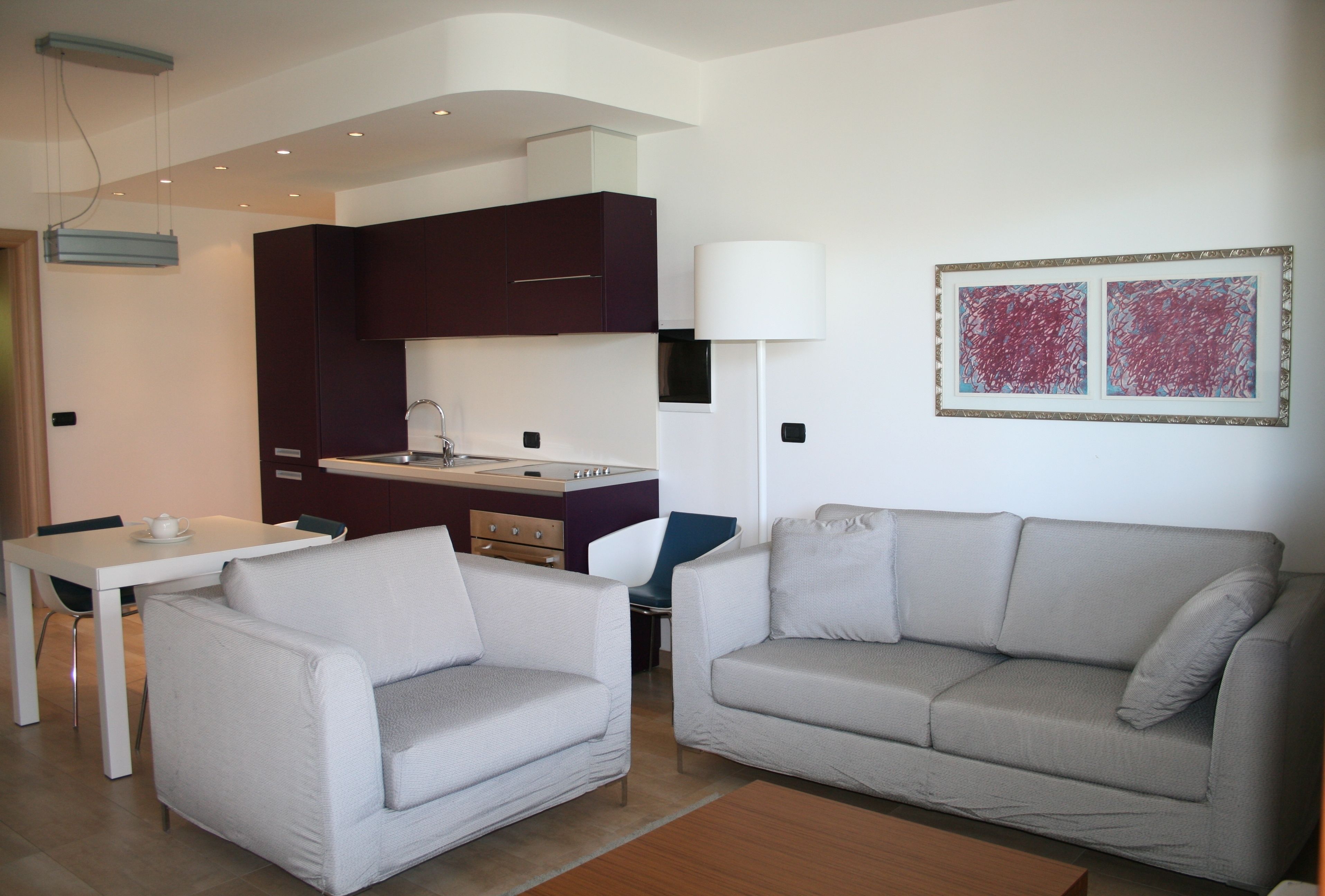 Ein modernes Wohnzimmer mit Sofa, Esstisch und Küchenzeile.