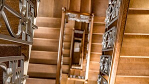 A wooden staircase with ornate metal railings and a mirrored wall. - Saint Feder (Lviv)