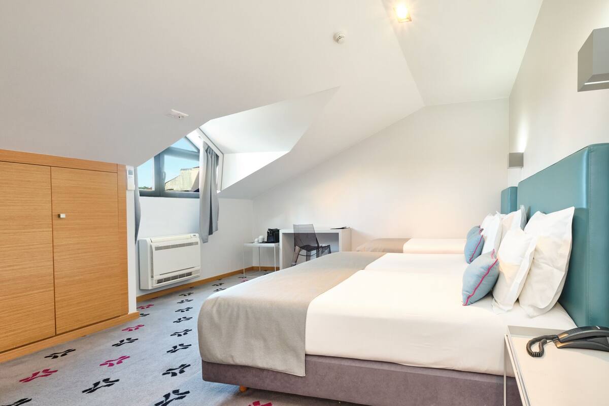 Una habitación de hotel moderna con una cama grande, un escritorio y un armario.