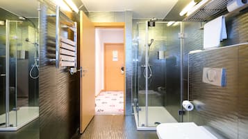 Un bagno moderno con doccia vetrata, un water e un lavandino.