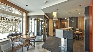 Un moderno hall de hotel con zona de comedor, una recepción y vistas al exterior.