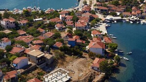 An aerial view of a coastal village with houses, a marina, and boats. - Drymna Hotel (Dorida)