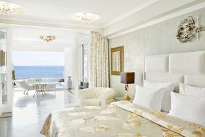 A spacious bedroom with a large bed, a view of the sea, and a balcony with a table and chairs. - The Danai (Sithonia)