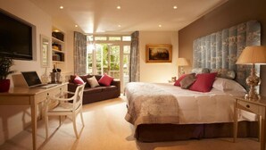 A bedroom with a large bed, a desk with a laptop, a chair, a sofa, and a window with curtains. - The Windsor Townhouse (Bath)