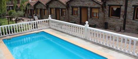 Een seizoensgebonden buitenzwembad, parasols voor strand/zwembad