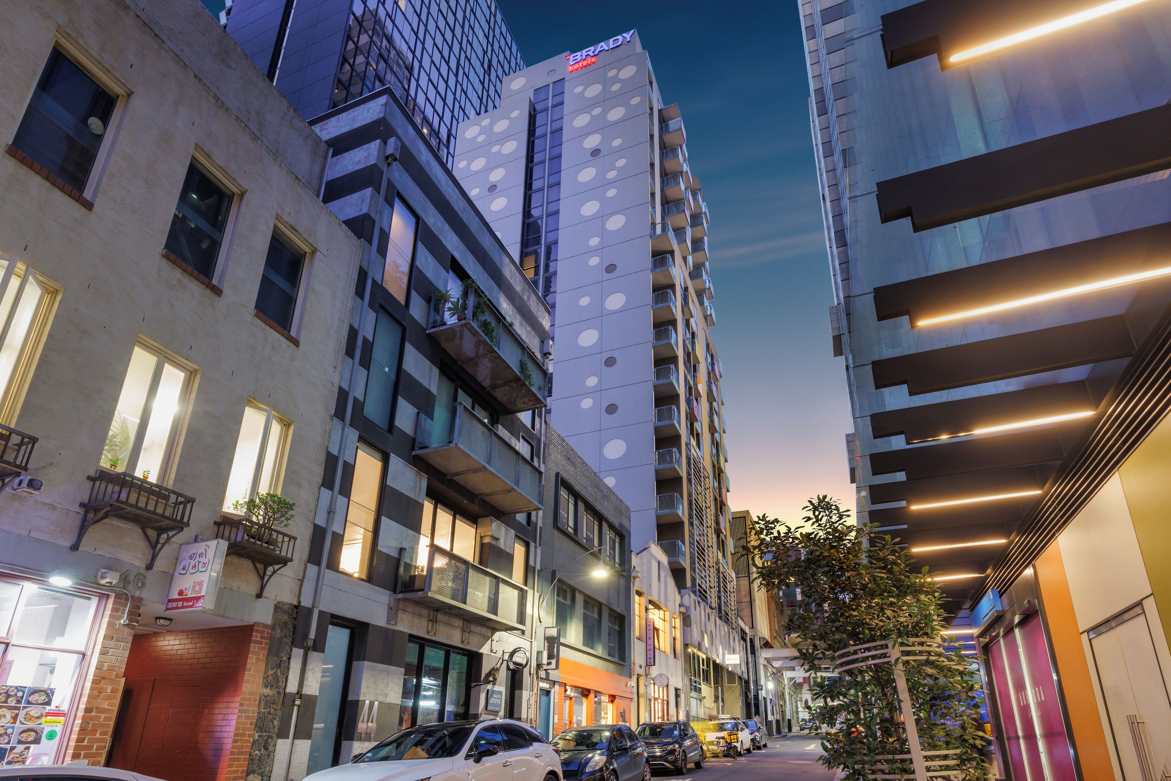 A modern hotel with a distinctive facade, multiple balconies, and a clear view of the street.