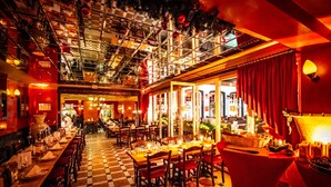 A restaurant with a checkered floor, long communal tables, and red curtains. - XII Apostel Hotel Albergo (Cologne)
