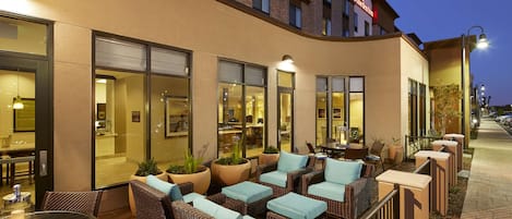 An outdoor seating area with wicker furniture and potted plants.