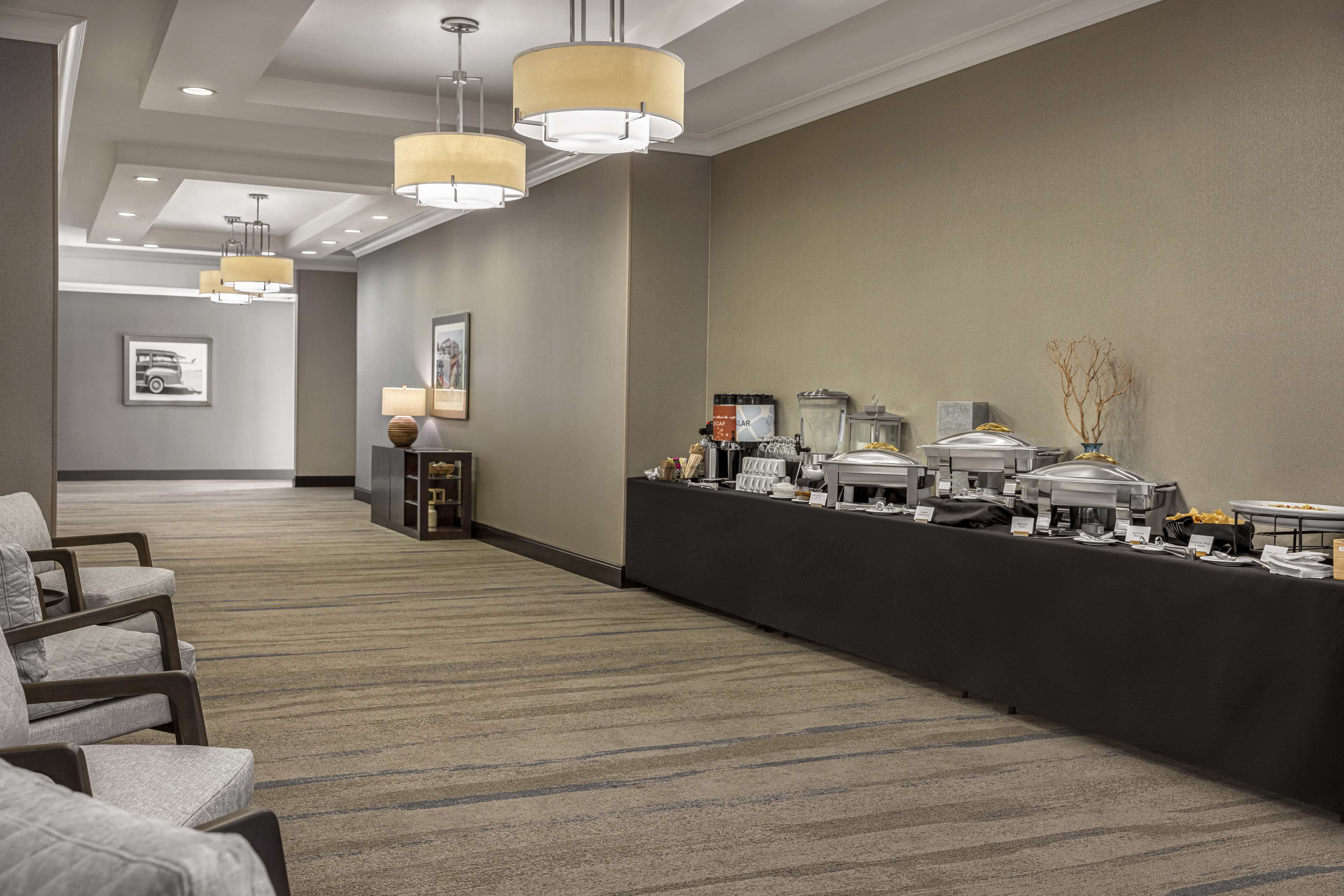 Una hall d'albergo con reception, area salotto e angolo buffet.