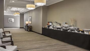Una hall d'albergo con reception, area salotto e angolo buffet.