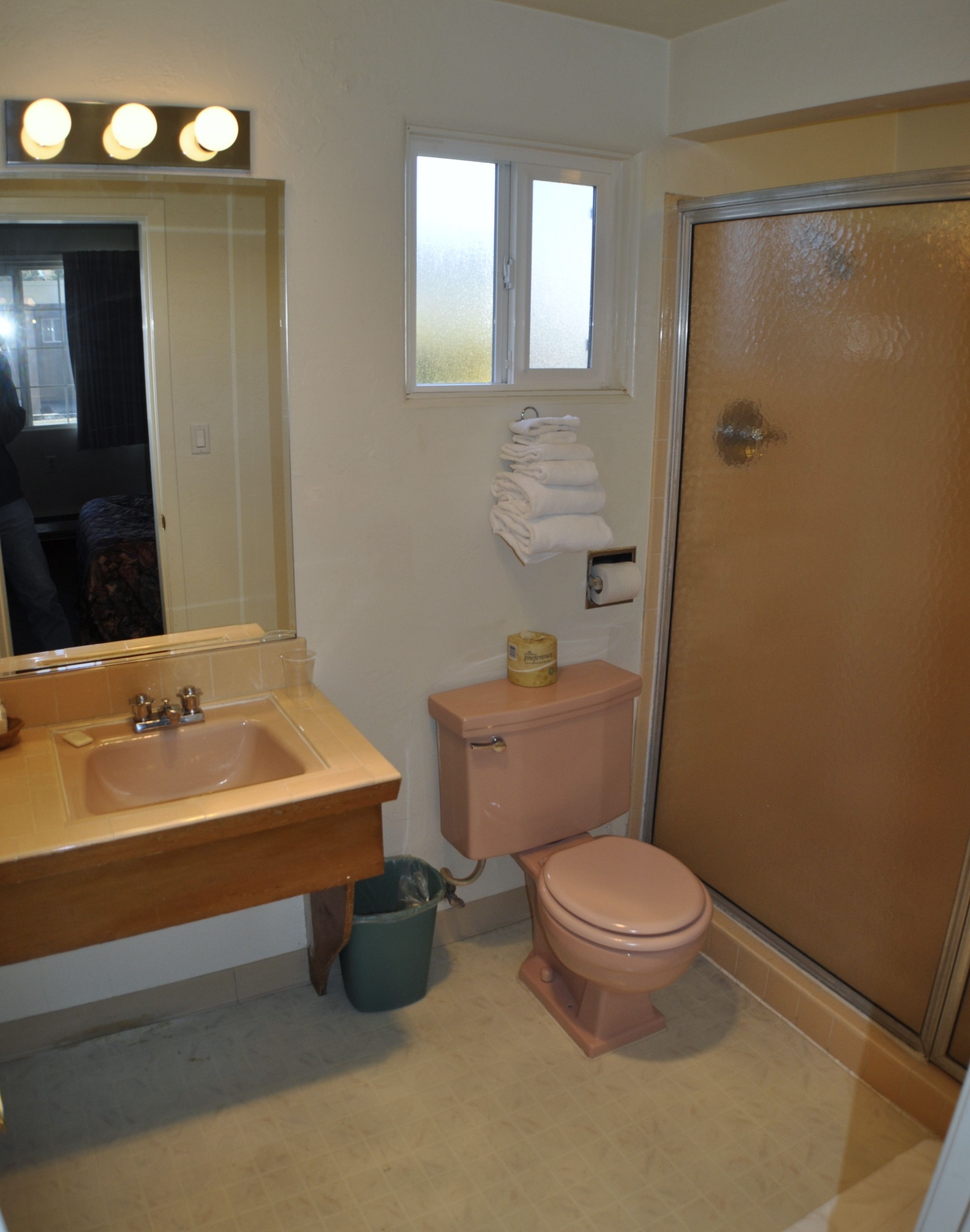 A bathroom with a sink, toilet, and a shower stall.